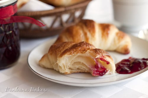 Croissants on a white plate with blackberry jam