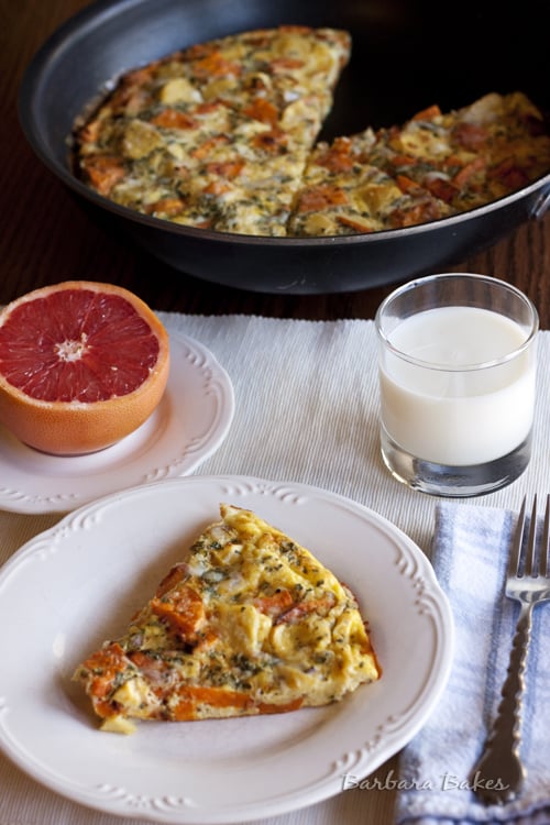 Roasted-Vegetable-Frittata on a white plate with half a grapefruit and a glass of milk