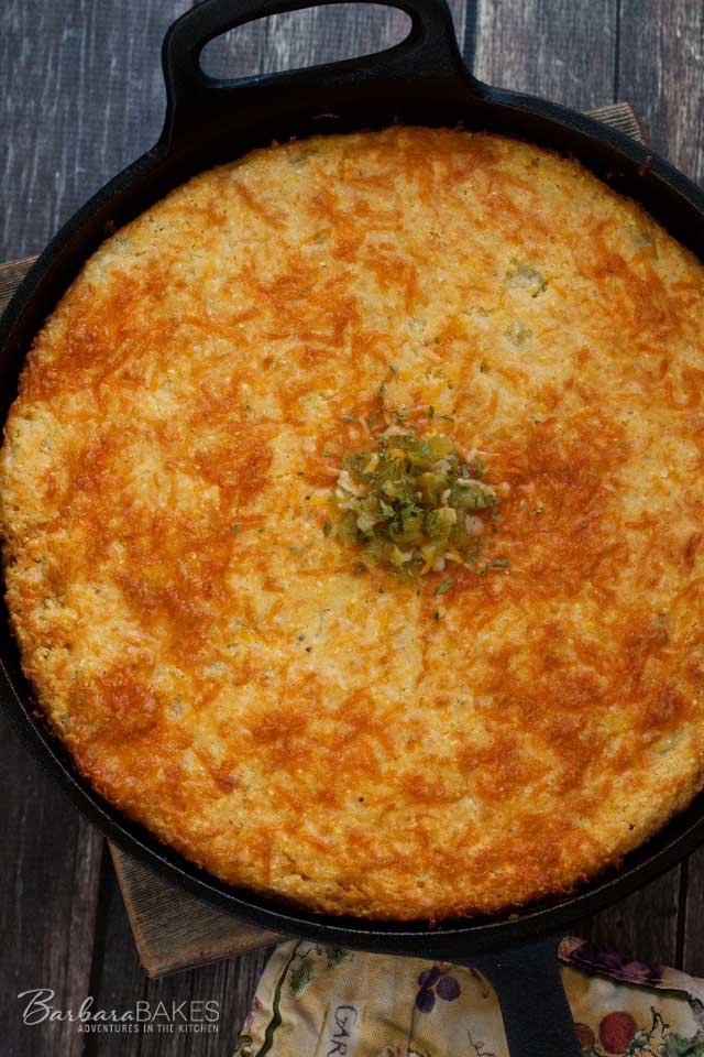 Cheesy Green Chile Cornbread baked in a hot cast iron skillet.