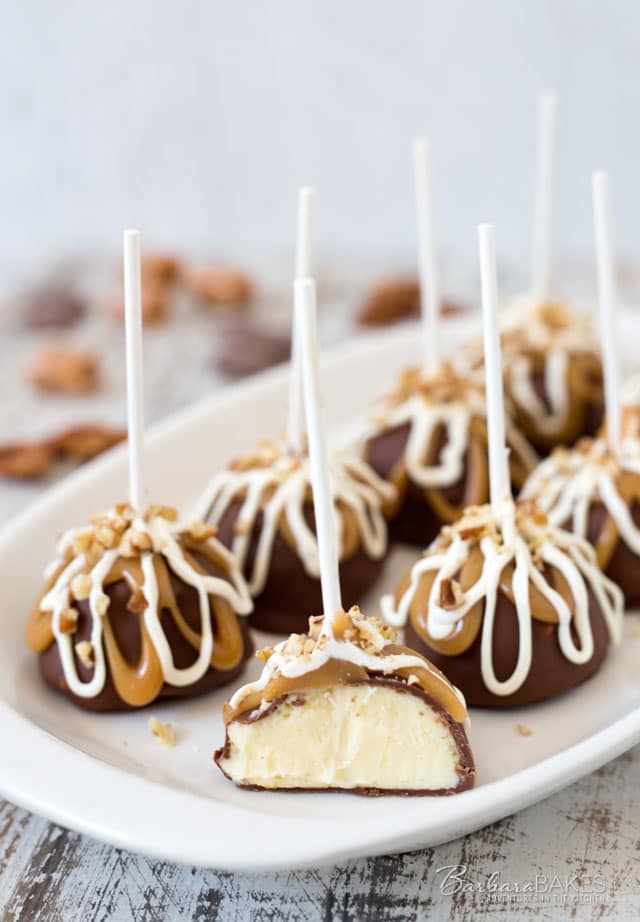 These Chocolate Covered Cheesecake Pops are decadently rich, smooth and creamy cheesecake covered in luscious milk chocolate then drizzled with caramel and white chocolate. 