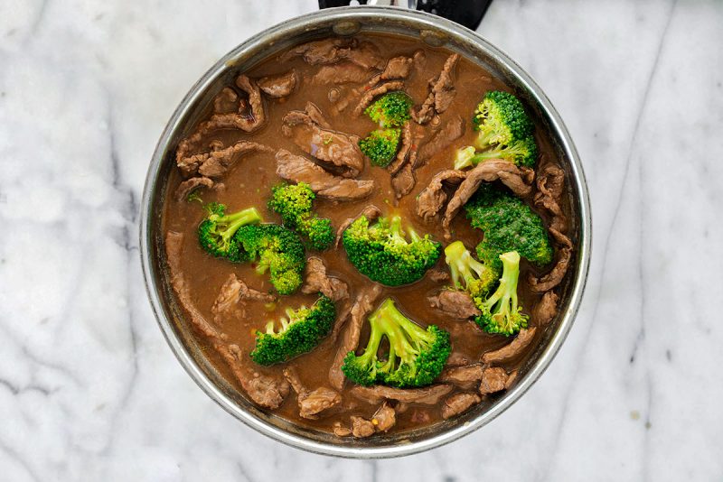 beef and broccoli in savory sauce in pan