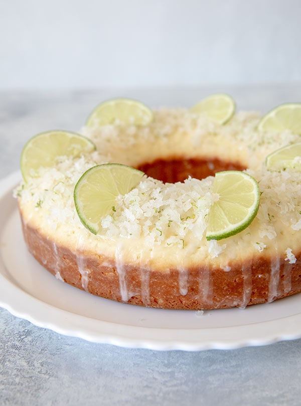 Coconut Lime Cake topped with shredded coconut and lime slices