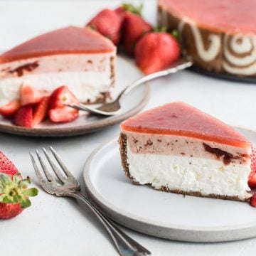 a slice of strawberry-lemon-cheesecake-entremet on a white plate with a fork