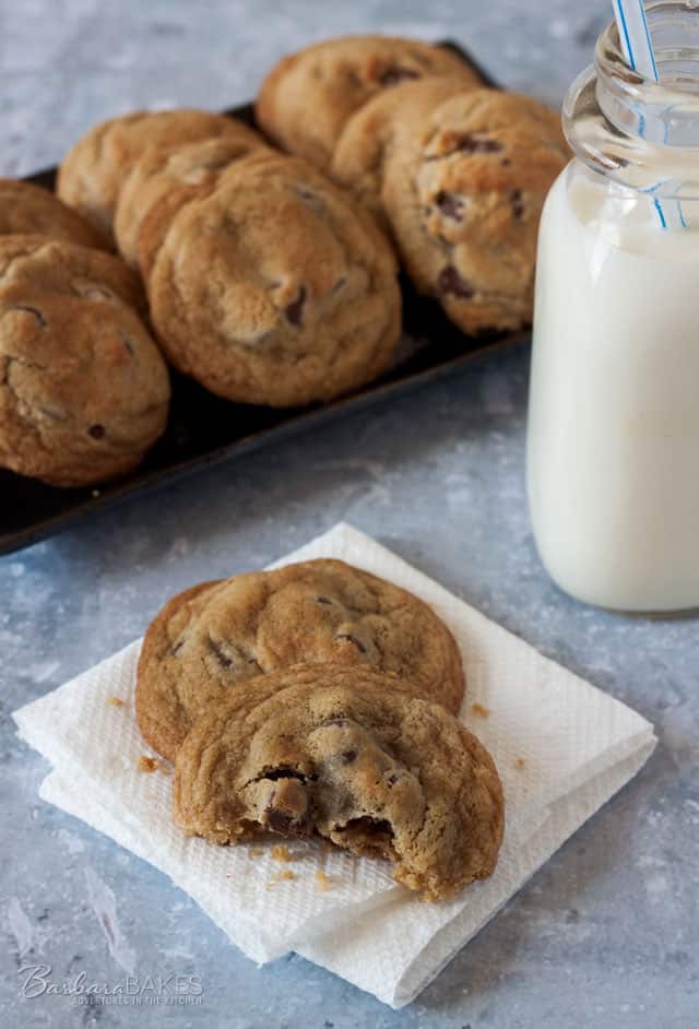Thick, Chewy Chocolate Chip Cookies on a platter with a mini jug of milk.
