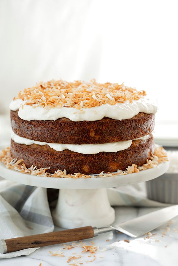 Two layer Tropical Carrot Cake with Toasted Coconut Cream Cheese frosting on a cake stand