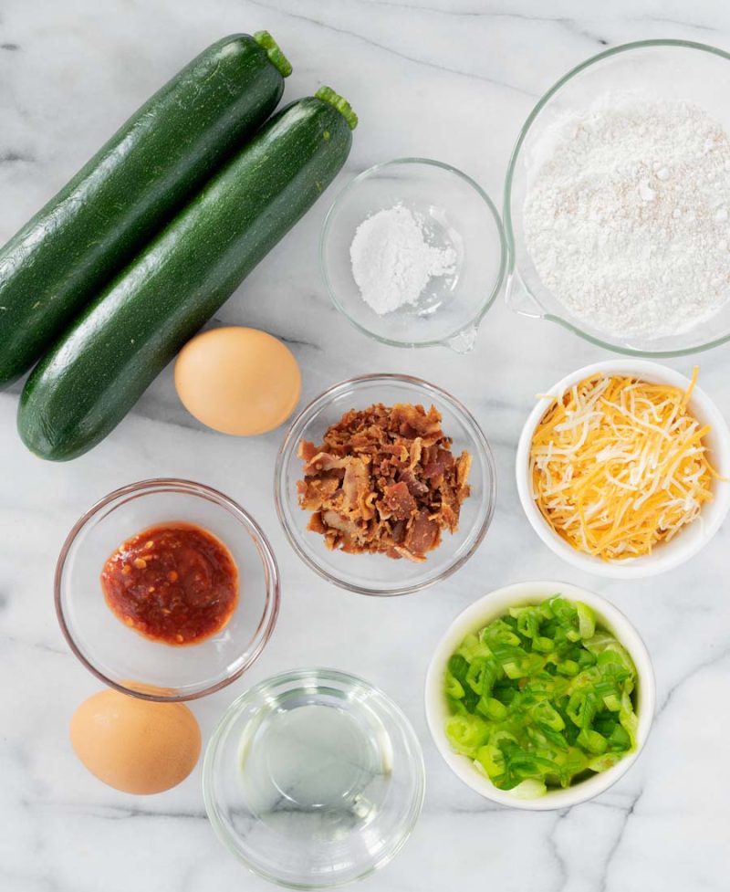 all the ingredients in zucchini fritters in different bowls