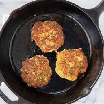 three zucchini fritters in a skillet