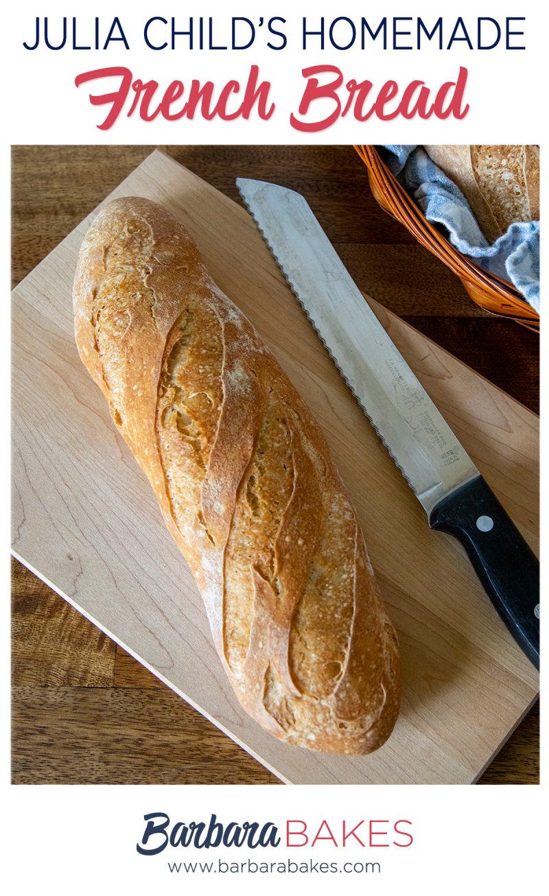 A small loaf of homemade French bread on a cutting board with a serrated knife