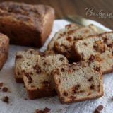 sliced snickerdoodle bread with cinnamon chips backed by two uncut loaves