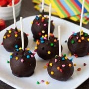 6 easy cake pops on a plate made with a brownie mix, covered in chocolate and sprinkles