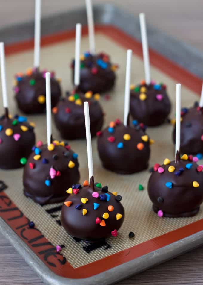 Brownie Cake Pops with Rainbow Candy Coated Chips sitting on a baking sheet
