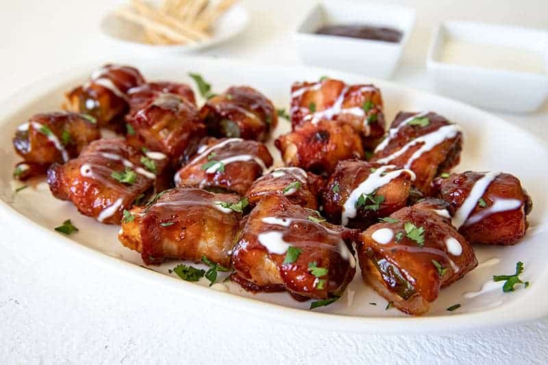 Bacon-Wrapped Chicken Stuffed Jalapeno Bites on a white platter