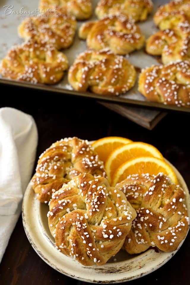 Swedish Orange Sweet Buns made with a buttery, cardamom dough layered with fragrant orange sugar, then knotted, topped with Swedish pearl sugar and baked until they're golden brown. 