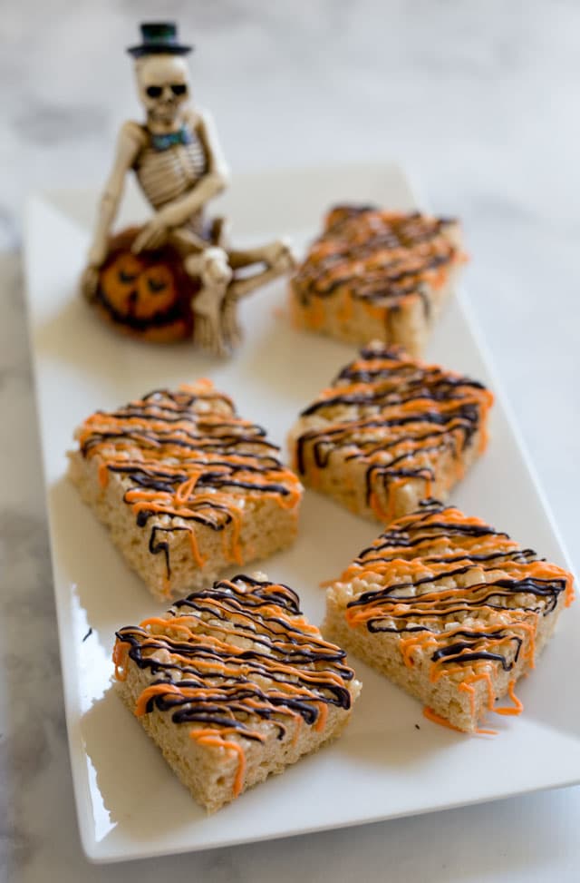 Crispy Treats dressed up with a drizzle of orange and black candy melts are the perfect treat this year for Halloween.