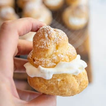 hand holding filled cream puff