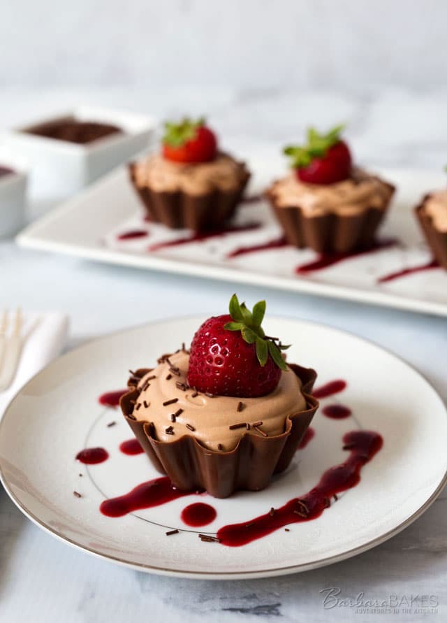A pretty, ruffled chocolate cup filled with a rich, creamy milk chocolate mousse topped with a fresh, sweet strawberry, real chocolate sprinkles and served with a berry coulis. 