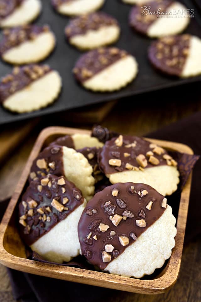 These Chocolate Dipped Caramel Shortbread Cookies are a delicious, sandy, buttery, caramel shortbread cookie dipped in chocolate and sprinkled with Heath toffee bits.