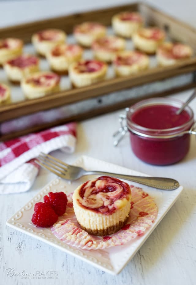 Rich, smooth, creamy cheesecakes swirled with tart raspberry curd in a fun mini size. These Raspberry Curd Mini Cheesecakes are a quick, easy-to-make stress-free dessert. 