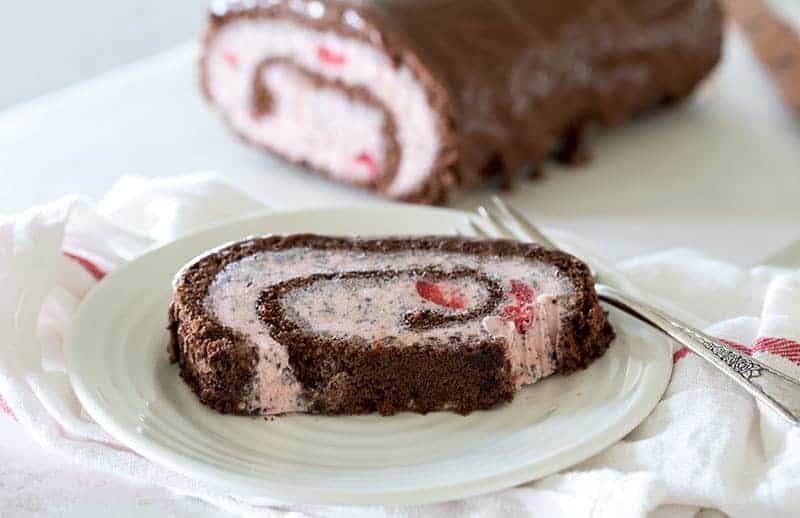 A fun-to-make, fun-to-eat Cherry Chocolate Chip Ice Cream Cake Roll dripping with chocolate ganache. A perfect summer dessert.