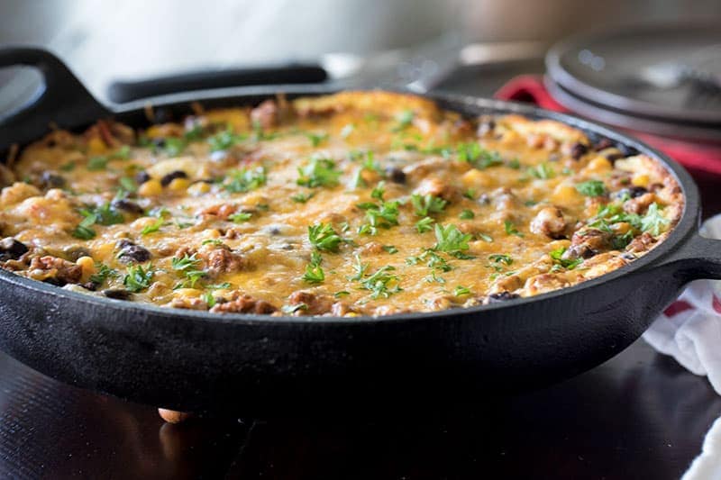 Cheesy tamale pie recipe cooked in a skillet