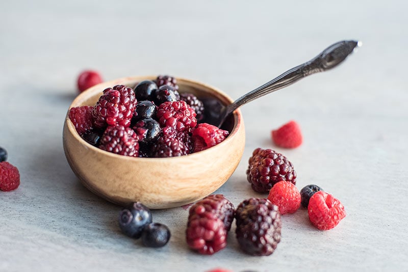 Triple Berry Compote with Fresh Berries in a wooden bowl with a spoon in it