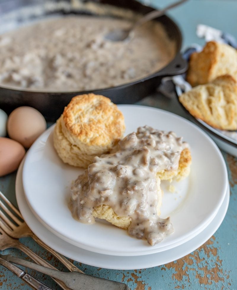 white plate with biscuits and gravy on it