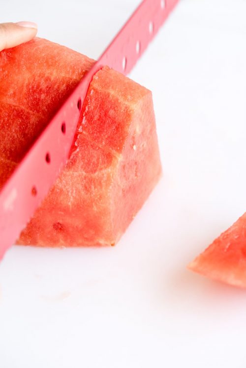 slicing a half of a watermelon into 1-inch wedges without a rind