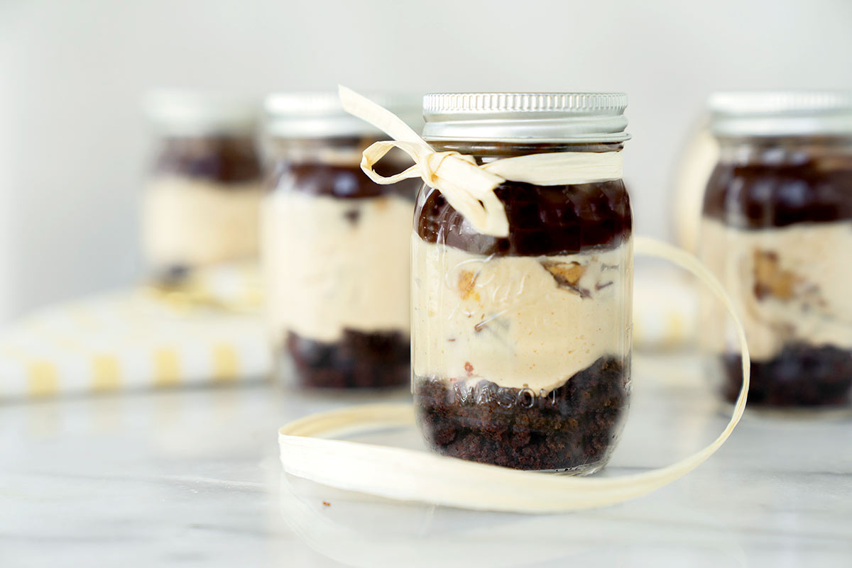 Several Mason jars with No-bake Peanut Butter Cheesecake in a Jar