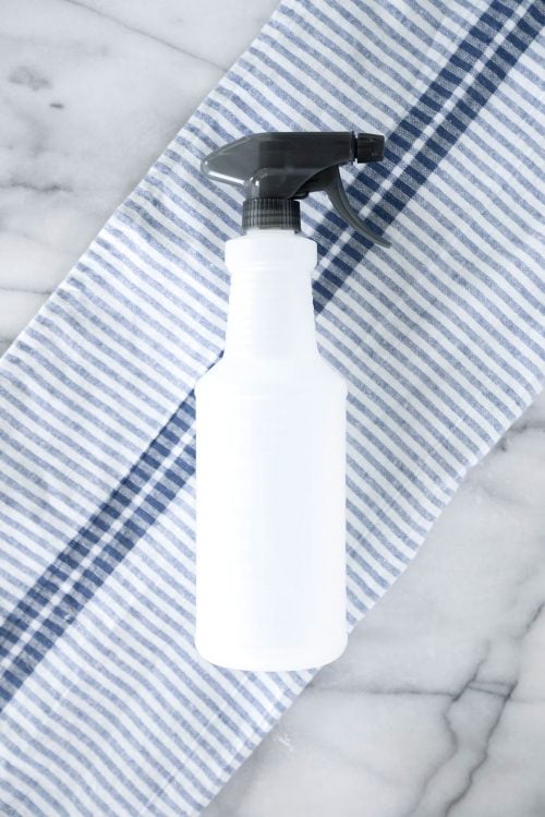 spray bottle on a blue striped napkin