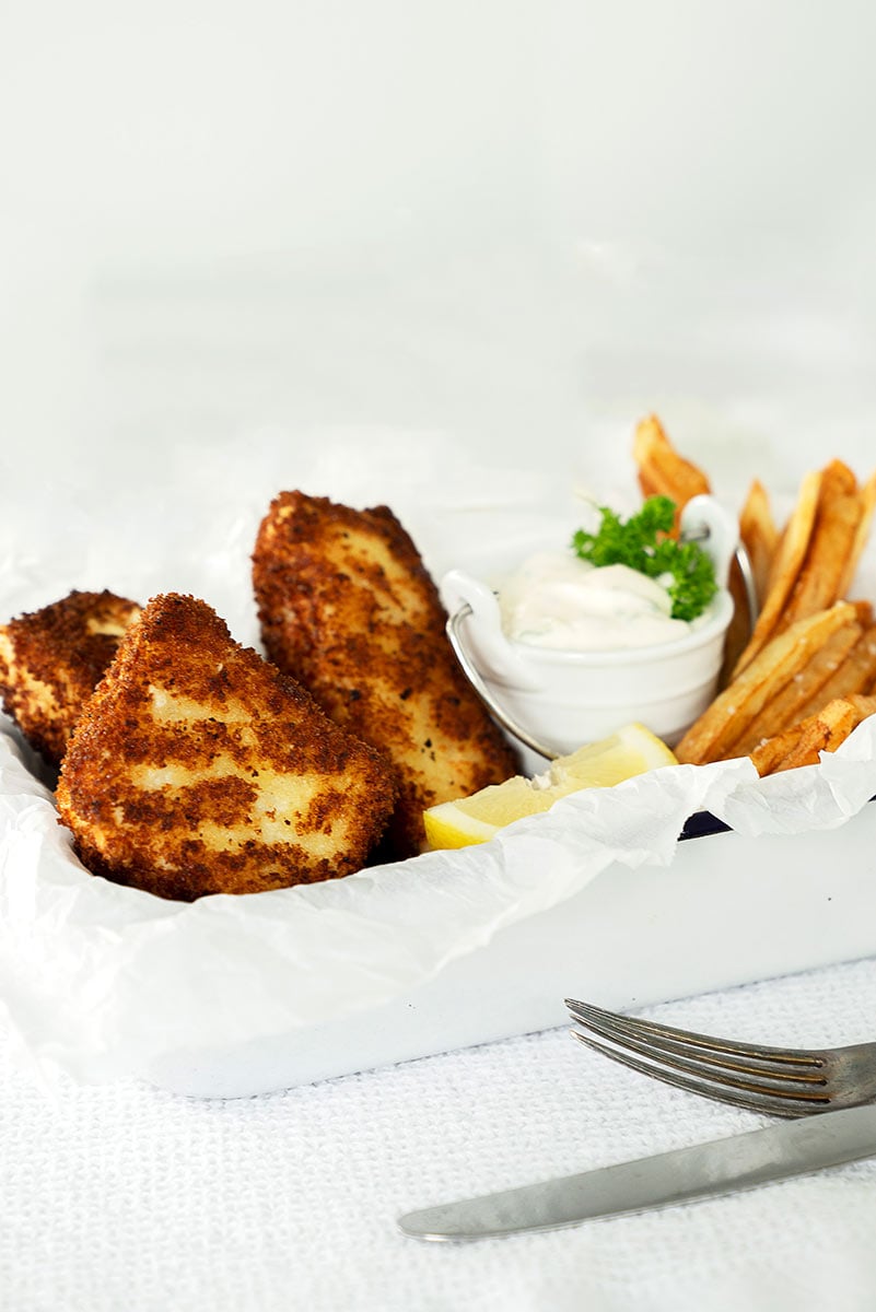 white tin with halibut fish and chips and lemon and tartar sauce