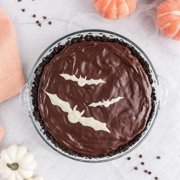 halloween cheesecake with chocoalte ganache and white bats for decoration