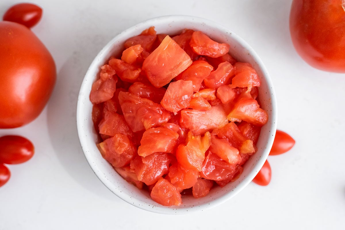 small white bowl with diced, peeled and de-seeded fresh tomato