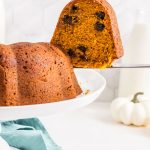 slice of pumpkin chocolate chip bundt cake on a white cake stand