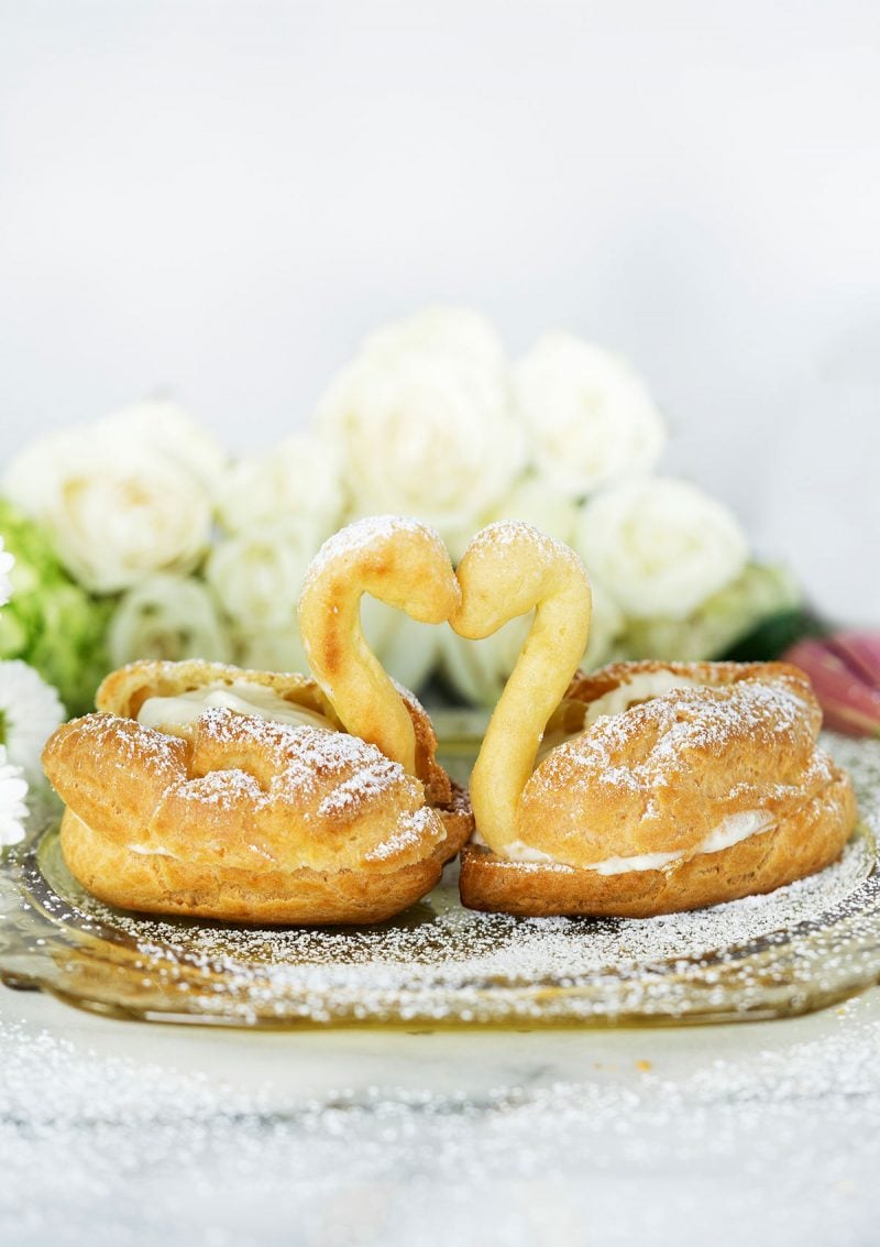 two cream puff swans with pastry cream and choux pastry