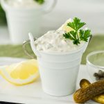 white bucket with homemade tartar sauce on a white plate