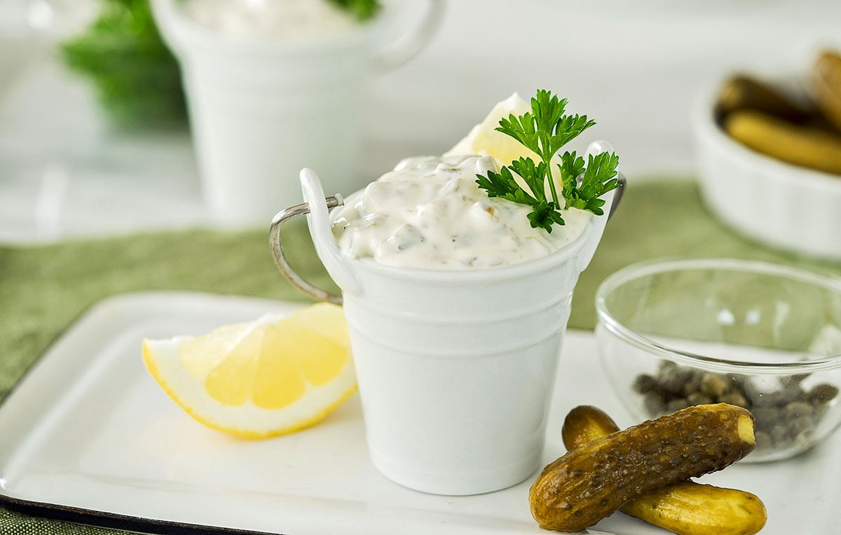 white bucket with homemade tartar sauce on a white plate