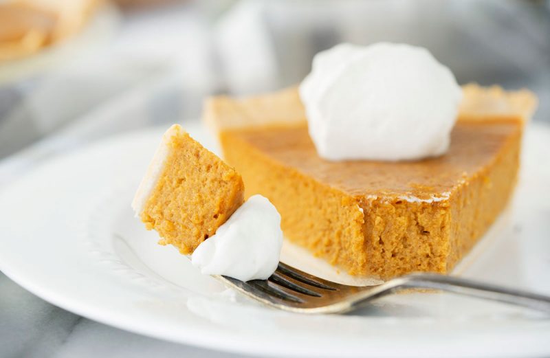 plate of pumpkin pie slice with whipped cream