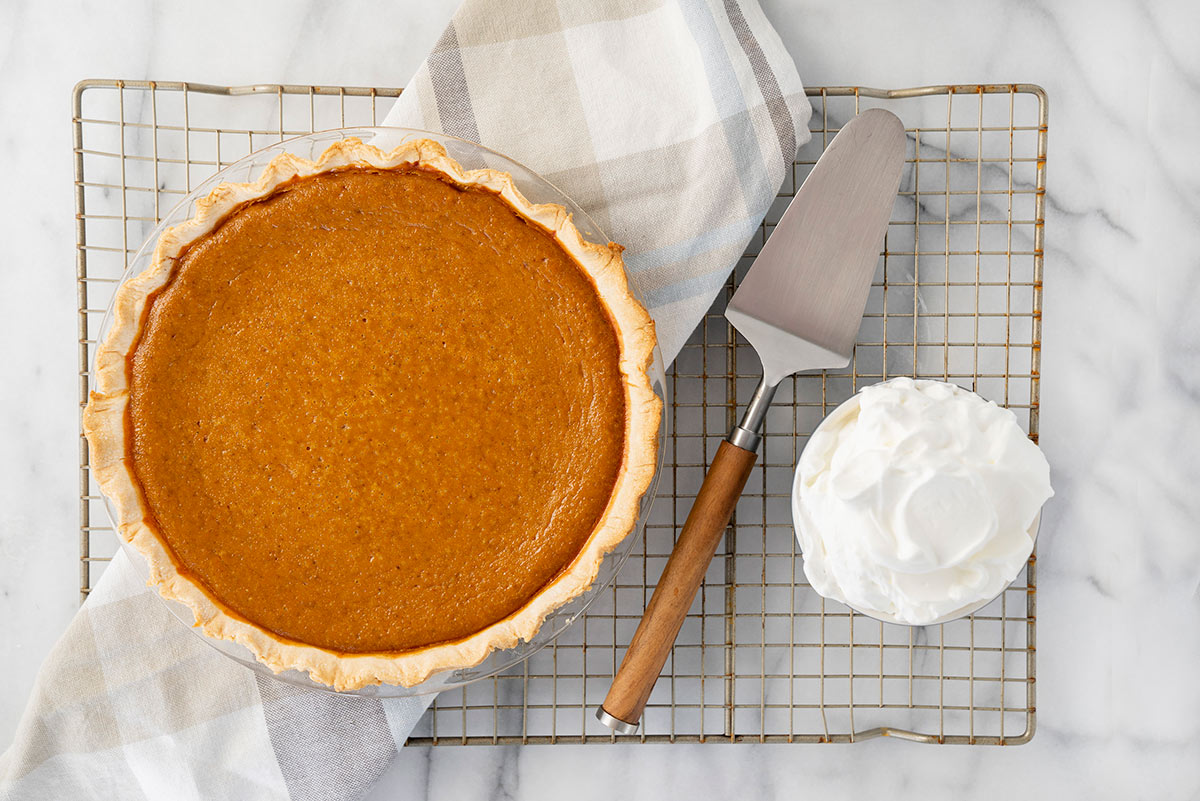 whole baked pumpkin pie on a cooling rack