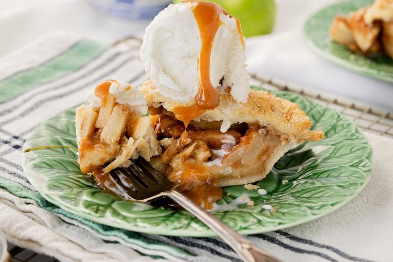 slice of homemade apple pie with ice cream and caramel sauce