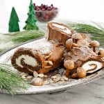 yule log cake on a serving platter with christmas decorations