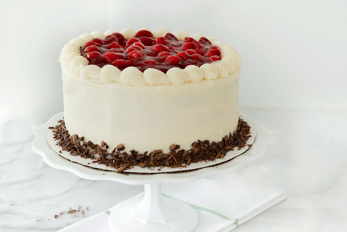 three layer black forest cake with cherries on top