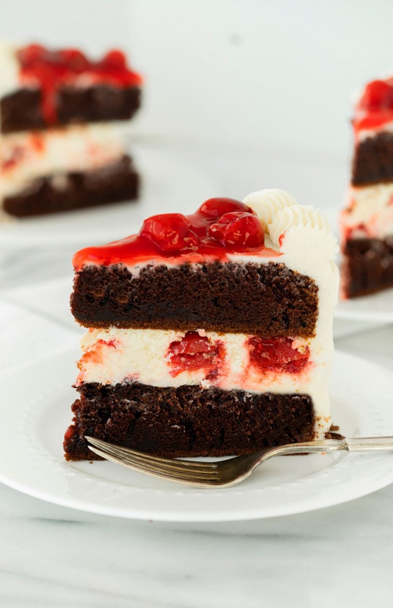 slice of black forest cheesecake cake with cherry pie filling