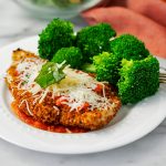 plat of light chicken parmesan with broccoli