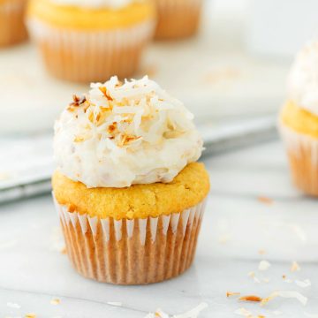 coconut cupcake with toasted coconut frosting on a marble countertop
