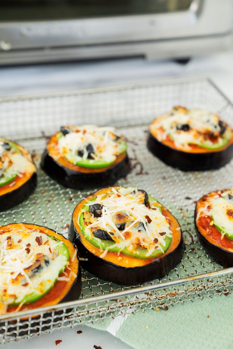 close up on a wire rack of cooked eggplant pizzas from the air fryer