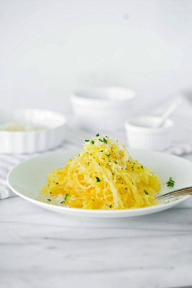 white plate of baked and stir-fried spaghetti squash