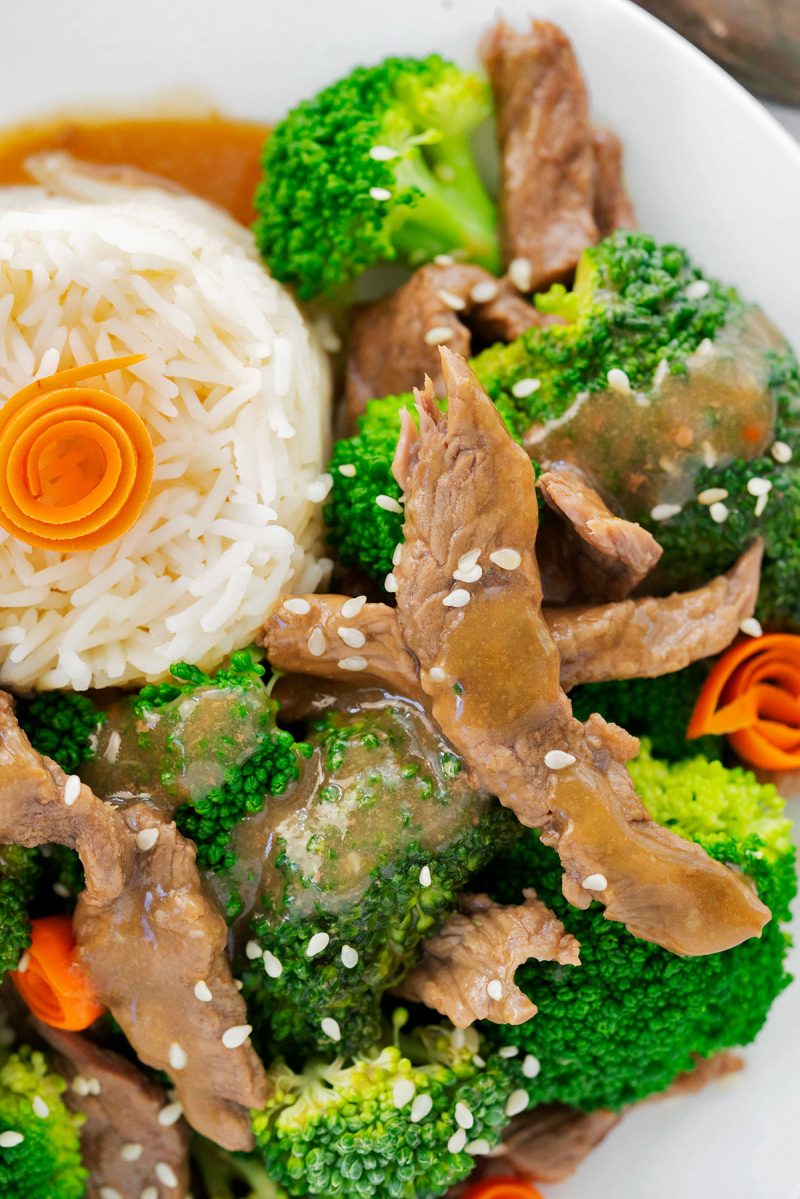 close up on beef and brocoli with white rice and sesame seeds