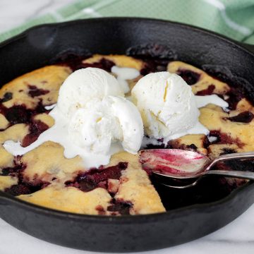 cherry cobbler in a skillet with ice cream