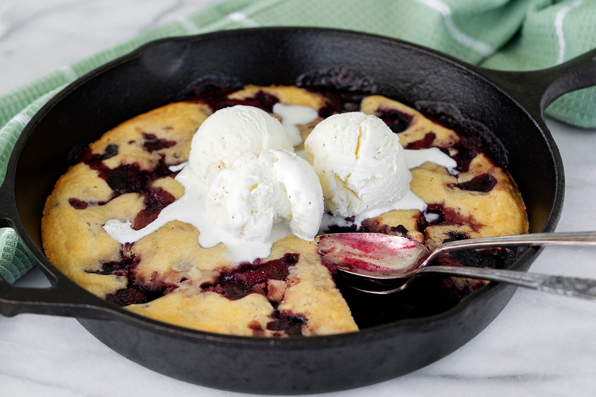 cherry cobbler in a skillet with ice cream