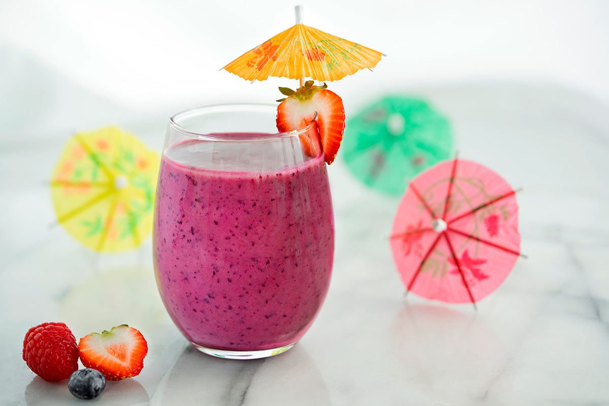 glass of pomegranate smoothie with a drink umbrella